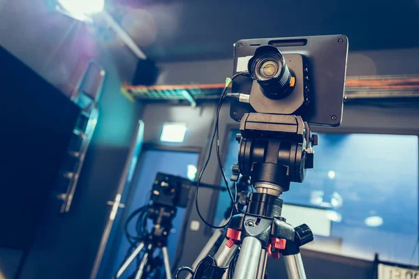 Film camera on a tripod in a television broadcasting studio, spotlights and equipment