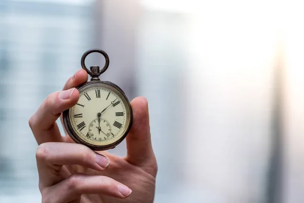 Time goes by: Man is holding a vintage watch in his hand, busine