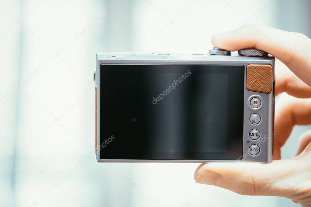 Reverse side of a digital camera, black lcd screen and some keys, business style