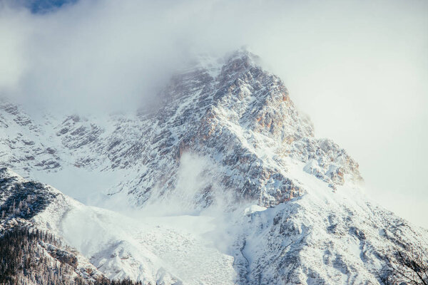 Epic snowy mountain peak with clouds in winter, landscape, alps, austri