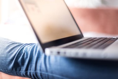 Kız mor tırnakları ile onu laptop evde kanepede kullanıyor
