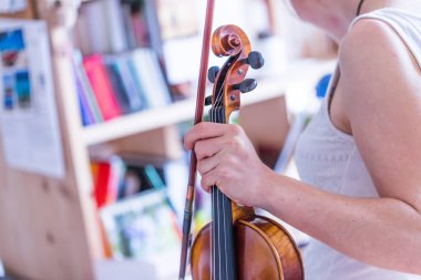 Güzel genç kız kemanıyla, akustik müziğiyle pratik yapıyor.