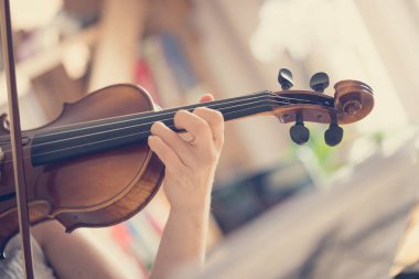 Güzel genç kız kemanıyla, akustik müziğiyle pratik yapıyor.