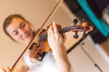 Güzel genç kız kemanıyla, akustik müziğiyle pratik yapıyor.