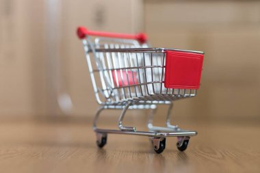 Online alışveriş ve parsel hizmet anlayışı: minyatür alışveriş sepeti ve karton kutular