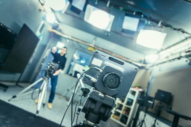 Bir televizyon yayın studio, sahne ışıkları ve donanımları, kameraman bulanık arka planda bir film kameranın lens