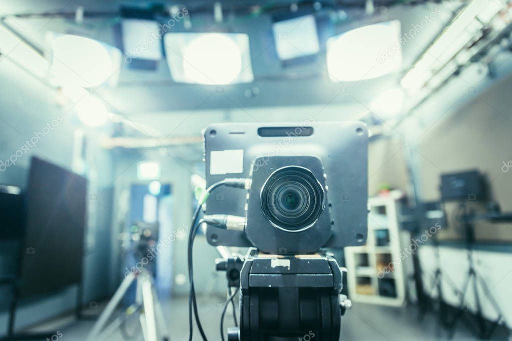 Lens of a film camera in an television broadcasting studio, spotlights and equipment