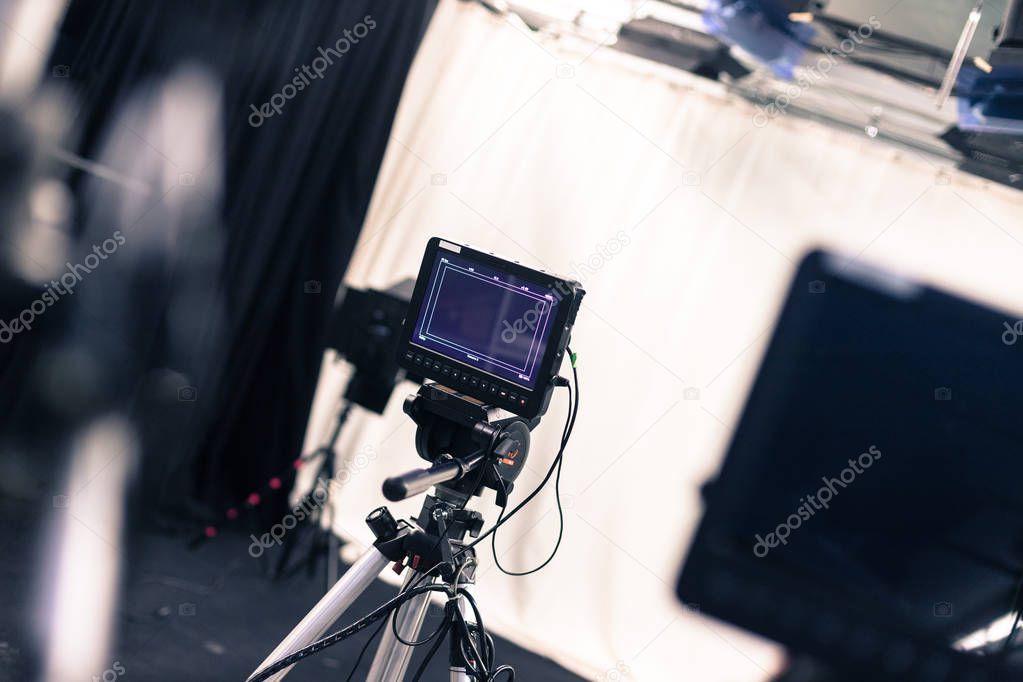 Film camera with lcd screen on a tripod in a television studio