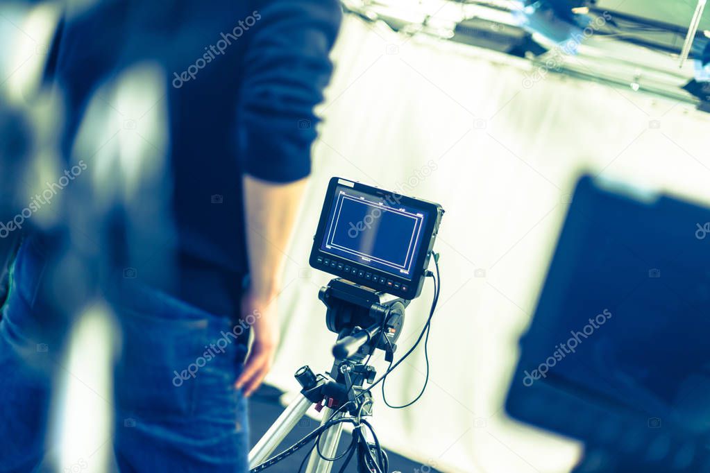 Male cameraman is operating a film camera in a television studio