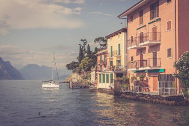Pastoral lago di garda akşam. Renkli sevimli İtalyan evleri, dağlar ve bulutlu gökyüzü