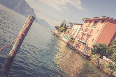 Pastoral lago di garda akşam. Renkli sevimli İtalyan evleri, dağlar ve bulutlu gökyüzü