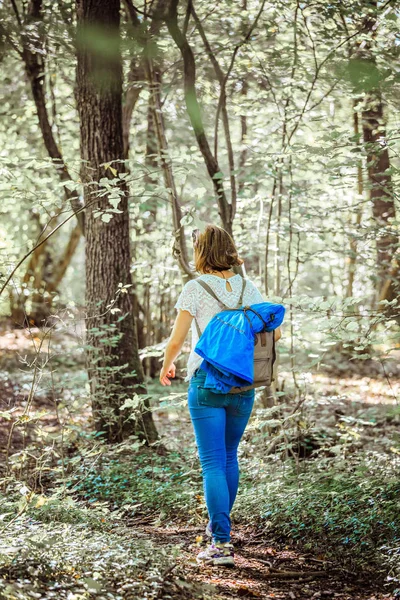 白种人年轻女子走在树林里 — 图库照片