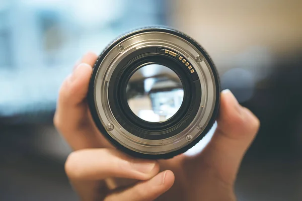 Photographer Holds Professional Photo Optic His Hand Laptop Blurry Background — Stock Photo, Image