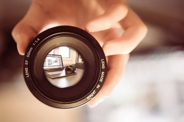 Photographer Holds Professional Photo Optic His Hand Laptop Blurry Background — Stock Photo, Image