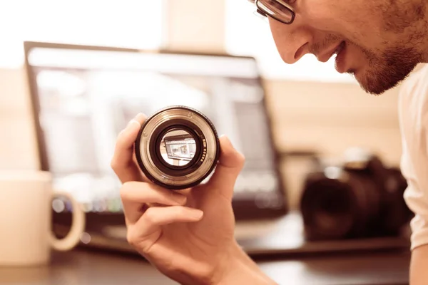 Ung Fotograf Tittar Ett Fotografi Objektiv Laptop Den Suddiga Bakgrunden — Stockfoto