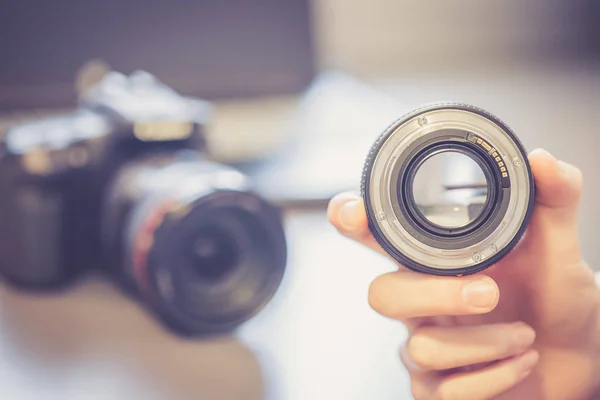 Fotógrafo Segura Uma Câmera Reflexa Com Lente Telefoto Mão Mesa — Fotografia de Stock