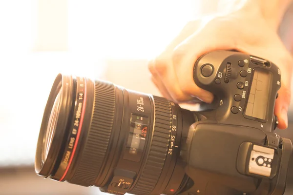 Fotógrafo Segura Uma Câmera Reflexa Com Lente Telefoto Mão Mesa — Fotografia de Stock