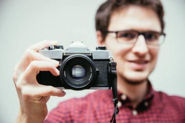 Kırmızı-mavi ekose desenli gömlek genç adam bir vintage fotoğraf makinesi, retro tarzı bir fotoğraf çekimi