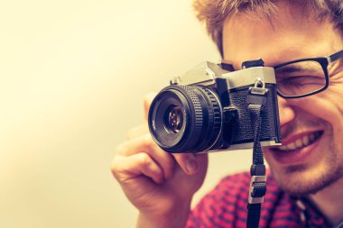 Kırmızı-mavi ekose desenli gömlek genç adam bir vintage fotoğraf makinesi, retro tarzı bir fotoğraf çekimi