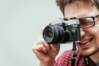 Kırmızı-mavi ekose desenli gömlek genç adam bir vintage fotoğraf makinesi, retro tarzı bir fotoğraf çekimi