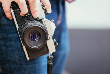 Adam elini, kot pantolon ve gömlek vintage bir kamera tutuyor