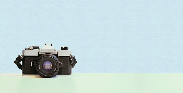 Retro vintage photography camera on blue colored background
