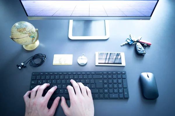 Workplace of a freelancer: Arrangement of computer, keyboard, credit card, compass, keys and globe