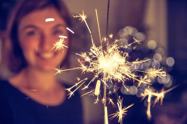 Smiling Girl Holding Sparkler Her Hand Indoor Lights Background — Stock Photo, Image