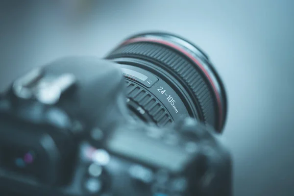 Professional reflex camera with telephoto lens on the table, cutout, blurry background