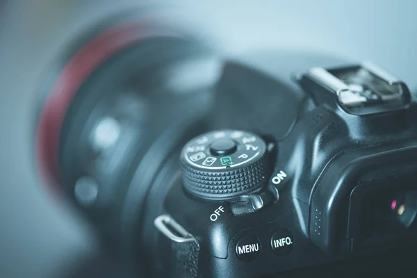 Professional reflex camera with telephoto lens on the table, cutout, blurry background