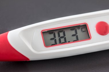 Kırmızı ateş termometre dijital gösterge ve masanın üzerinde yatan 38 santigrat derece ile