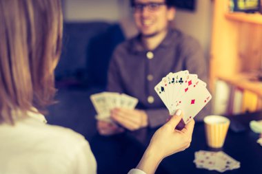 Kart evde oynamak: arkadaşlar bir masada oturuyor. Oyun kartları, dostum bulanık arka planda kadın.