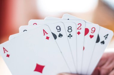 Young man is playing cards, cutout of his hands clipart