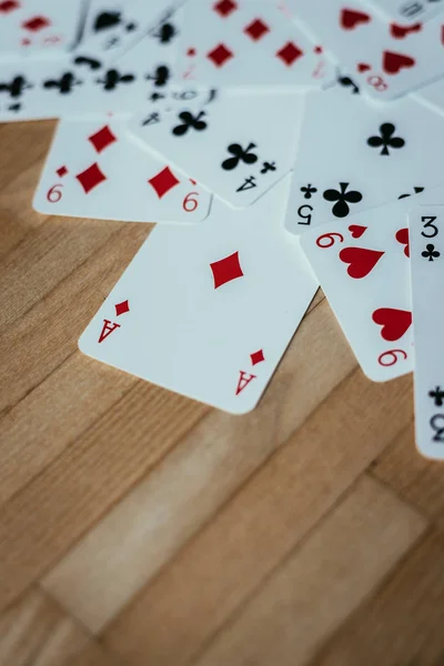 Gaming cards are lying on wood table. Playing cards at home, copy space.