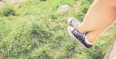 Siyah spor ayakkabı ve yeşil çim yaz aylarında: ücretsiz bir süre için genç için