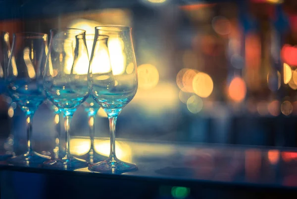 Wine glasses in a night club, colourful lights in the blurry background