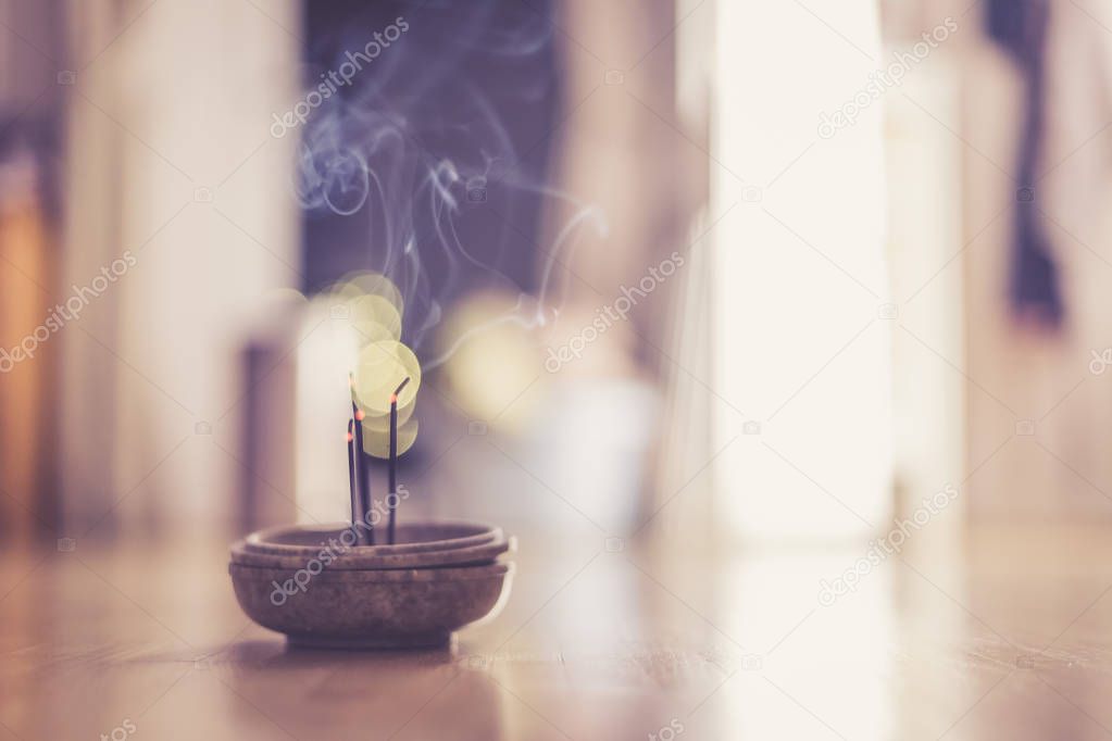 Joss sticks in smoking bowl are smoking and smelling, home, feng shui; Copy space;