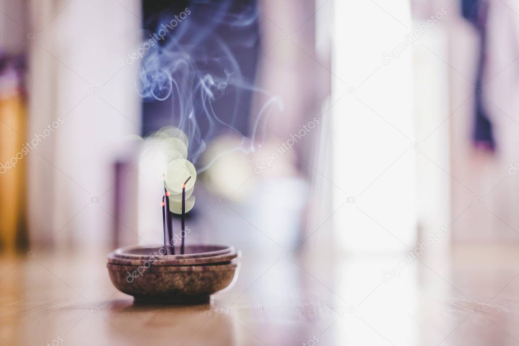 Joss sticks in smoking bowl are smoking and smelling, home, feng shui; Copy space;