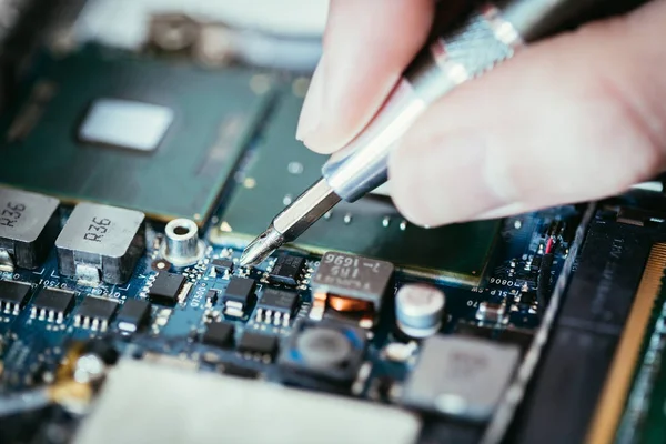 Technicus is tot vaststelling van een printplaat van de computer-, hand- en screwdri — Stockfoto