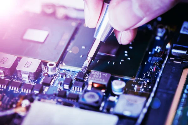 Technician is fixing a computer circuit board, hand and screwdri — Stock Photo, Image