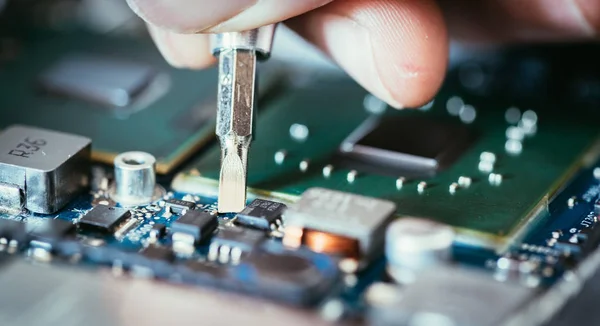 Técnico está fijando una placa de circuito informático, mano y tornillo — Foto de Stock