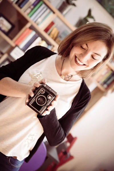 Beautiful laughing girl with a vintage film camera