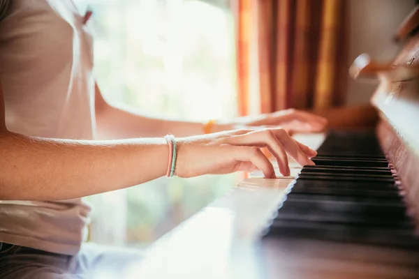 Girl is playing piano at home, high angle view, blurry backgroun — Stock Photo, Image