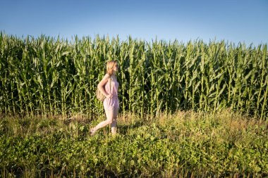 Genç kız bir yürüyüş bir alanda, yaz saati alıyor