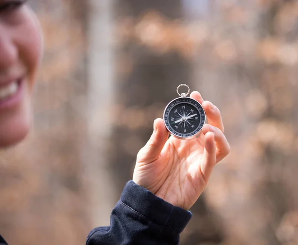 Compass holding in the hand of a girl, outdoor adventure, blurry