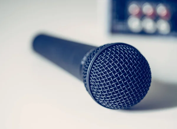 Black microphone and mixer in the blurry background — Stock Photo, Image