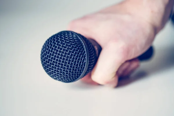 Microphone holding in hand with white background — Stock Photo, Image