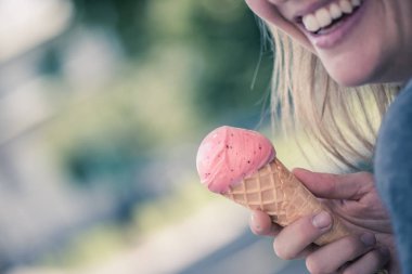 Gülümseyen kız ona çilekli dondurma bir yaz günü sırasında hoşlanır.