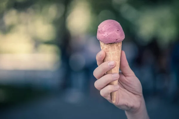 Жінка тримає полуничне морозиво в руці, красива сума — стокове фото
