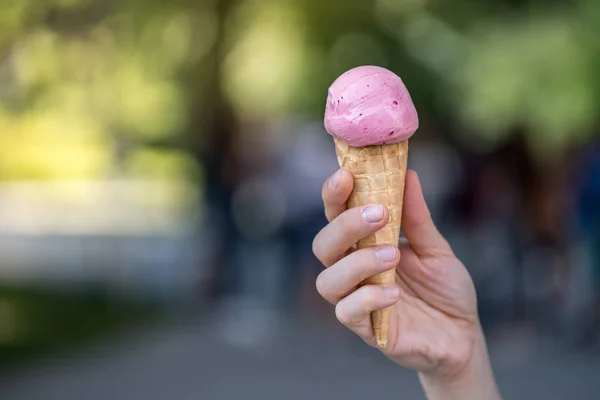 Woman is holding strawberry ice cream in her hand, beautiful sum — Stock Photo, Image
